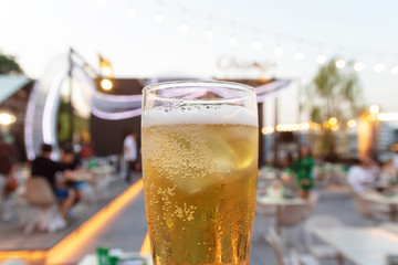 Glass of beer with abstract blurred background of bar and restaurant.