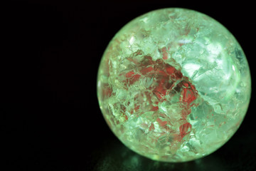 Glowing crystal ball with cracks inside on a dark background. The process of predicting the future