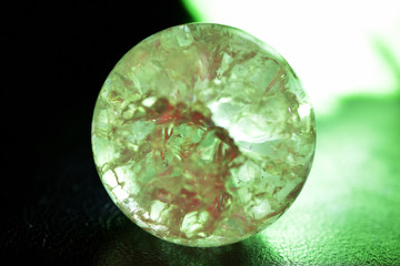 Glowing crystal ball with cracks inside on a dark background. The process of predicting the future
