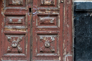 A fragment of an old wooden door with peeling paint. Selective focus.