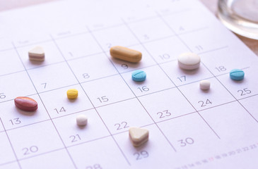 bunch of different pills on a calendar background. concept Healthcare