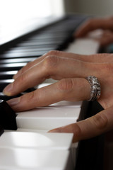 Fototapeta na wymiar A Close-up of the Fingers of a Married Women Playing the Piano - Key Board - In Alaska. 