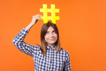 Popularity in social media. Portrait of funny brunette woman wearing checkered casual shirt holding...