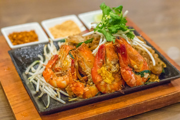 fried pad thai flat rice noodles thai style with prawns and bean sprouts with peanuts and lime on the side