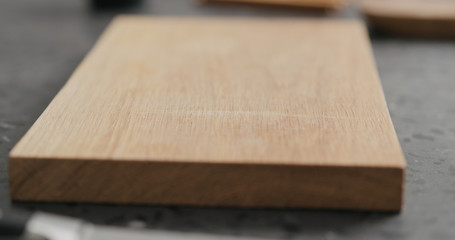empty oak cutting board on terrazzo countertop