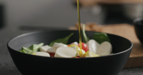 Closeup making salad with spinach, tomatoes and mozzarella