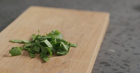 chopped fresh spinach leaves on oak cutting board