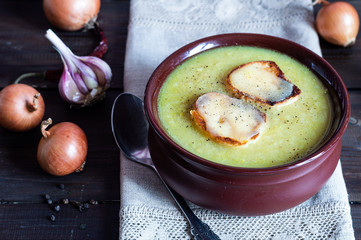 Onion soup with ingredients onions, cheese, toasts, dark wooden background