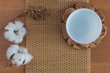 Empty cup on a wooden stand with cotton