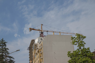 A crane in a construction work. Building crane. Lifting crane build multi-storey building