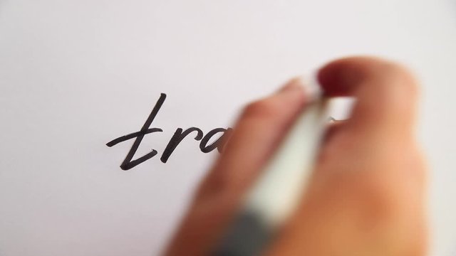 Hand writing Trader on white paper