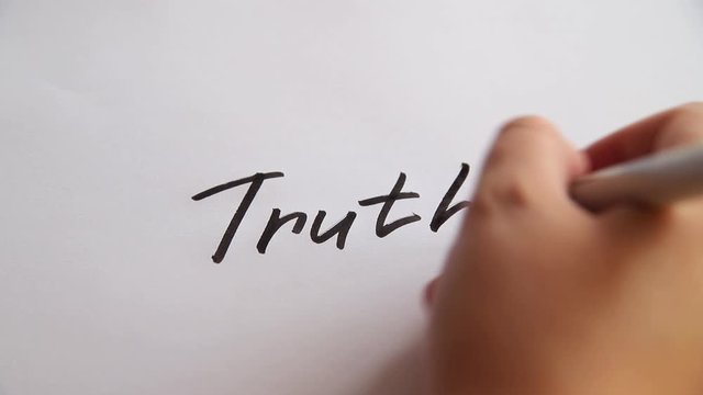 Hand writing Truth on white paper