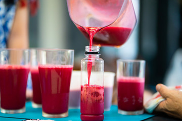 Close up Father make beetroot with passion fruit juice with Electric centrifugal juicer doing cook fresh vitamin in summer juice smoothie cocktail on kitchen.Raw healthy food concept.