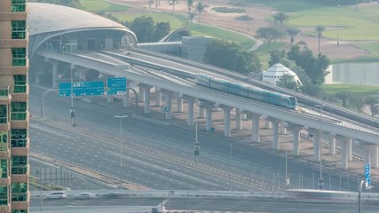 Metro station services both the Dubai Internet City and Dubai Media City districts of Dubai, as well as Golf Club morning timelapse. Aerial view from Dubai marina with traffic on a highway