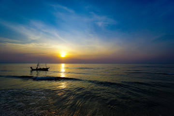 Colorful Sunrise with Sand and boat on the ocean at Huahin Thailand .