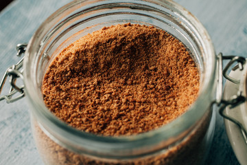 Close up view of raw cane sugar in a jar. Panela brown sugar background.. 