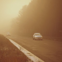 Cars in the fog. Bad winter weather and dangerous automobile traffic on the road. Vehicles in fog.
