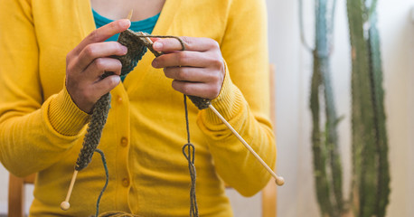 Young woman is knitting.