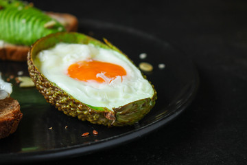 fried eggs in avocado (healthy food, vitamins) menu concept. food background. top view. copy space