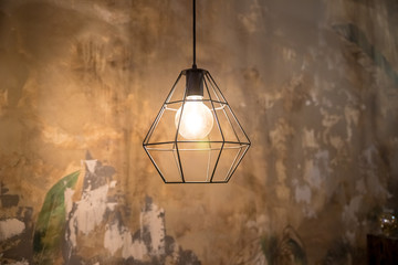 Industrial style wire lamps with filaments glowing inside glass light bulbs in darkness. Shiny...