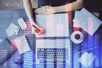 Financial graph displayed on woman's hand taking notes background. Concept of research. Multi exposure