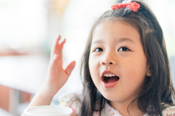 Little asian girl drinking soft drink soda in restaurant.