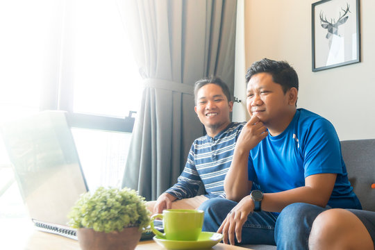 Asian Malay Friends At Apartment Watching Movie At Laptop Together