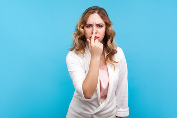 You are liar. Portrait of upset woman with wavy hair in white jacket touching nose showing lie...