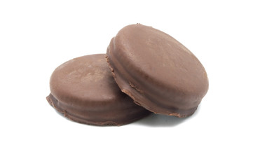 Chocolate sandwich cookies filled and coated with chocolate cream isolated on white background.