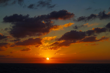 Amazing and beautiful sunrise or sunset over the ocean or sea with sun and sky on fire