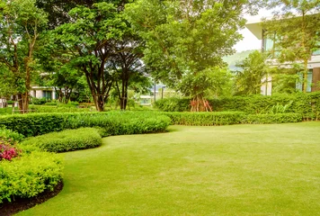 Fotobehang Huis in het park, Groen gazon, voortuin is prachtig aangelegde tuin, Bloemen in de tuin, Groen gras, Modern huis met mooi aangelegde voortuin, Gazon en tuin wazige achtergrond. © singjai