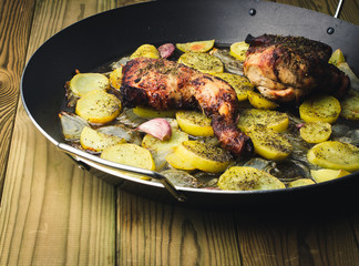 Chicken with Potatoes, Onion and Baked Garlic on Wooden Table