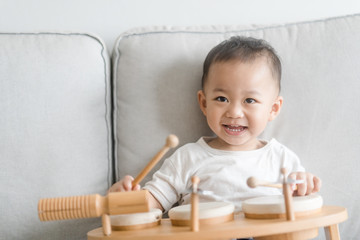 Little baby drummer boy playing and hitting the drum set at home.Asian boy playing and singing happy moment in music lesson time.Child development and Executive function in child concept.