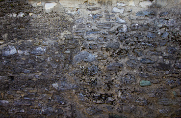 Texture del mura di cinta dell'antico casale tra mattoni e vecchi sassi.