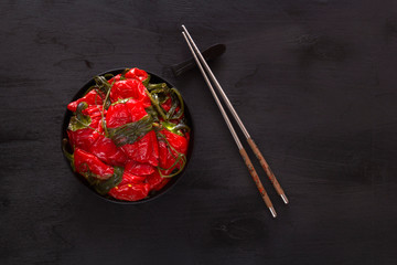 Fermented red hot peppers on a black table - traditional Korean food. Copy space. Top view