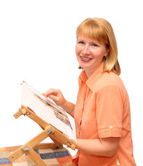 Young smiling woman embroiders on a frame
