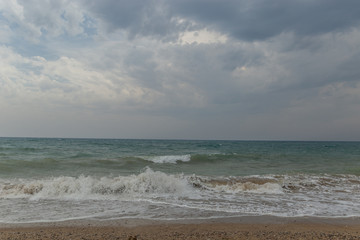 Storm on the beach, dark cloudy sky and waves