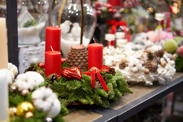 Assortment of European flower shop. Beautiful festive wreath of fresh spruce. Christmas mood. Xmas tree. Bokeh of Garland lights on background