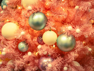 Christmas tree with gold bauble ornaments. Decorated Christmas tree closeup. Balls and illuminated garland with flashlights. New Year baubles macro photo with bokeh. Winter holiday light decoration