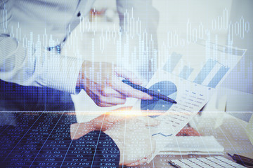 Financial trading graph double exposure with man desktop background.