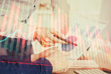 Financial trading graph double exposure with man desktop background.