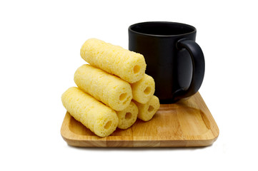 Coffee brake of sweet crunchy corn sticks, snacks on the wooden saucer with black coffee, isolated on white background.