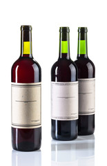 Bottles of red wine isolated on white background. Old empty paper labels.