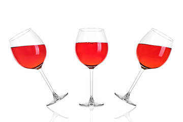 Three full glasses of rose wine half filled isolated on white background.
