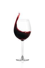 Glass of red wine isolated on white background. Wine spills out of the glass.