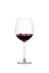 A glass of red wine half filled, isolated on a white background. The wine boils in the glass.