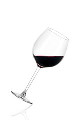 A glass of red wine half filled, isolated on a white background. The glass is tilted to the right.