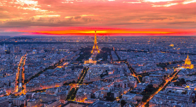 Paris, France - June 30, 2017: Tour Eiffel, the Invalids and aerial metro line at twilight red sky from terrace of Tour Montparnasse. Panoramic view of Paris skyline. Night urban scene.
