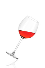 A glass of rose wine half filled, isolated on a white background. The glass is tilted to the right.