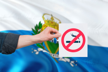 San Marino health concept. Hand holding paper with no smoking sign over national waving flag. Quit...